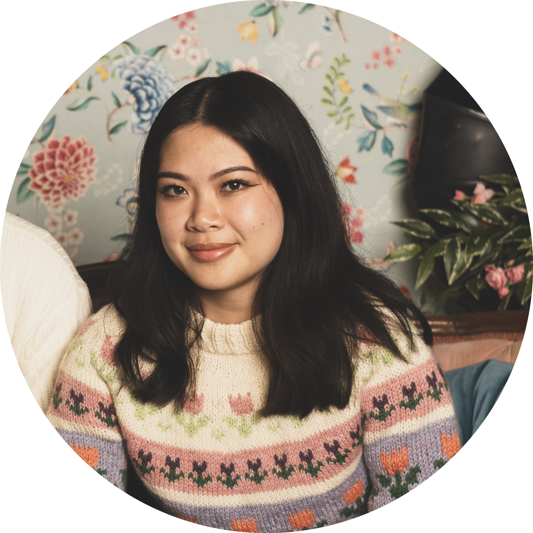 photo of vi nguyen wearing a knitted tulip sweater in front of a floral wallpaper